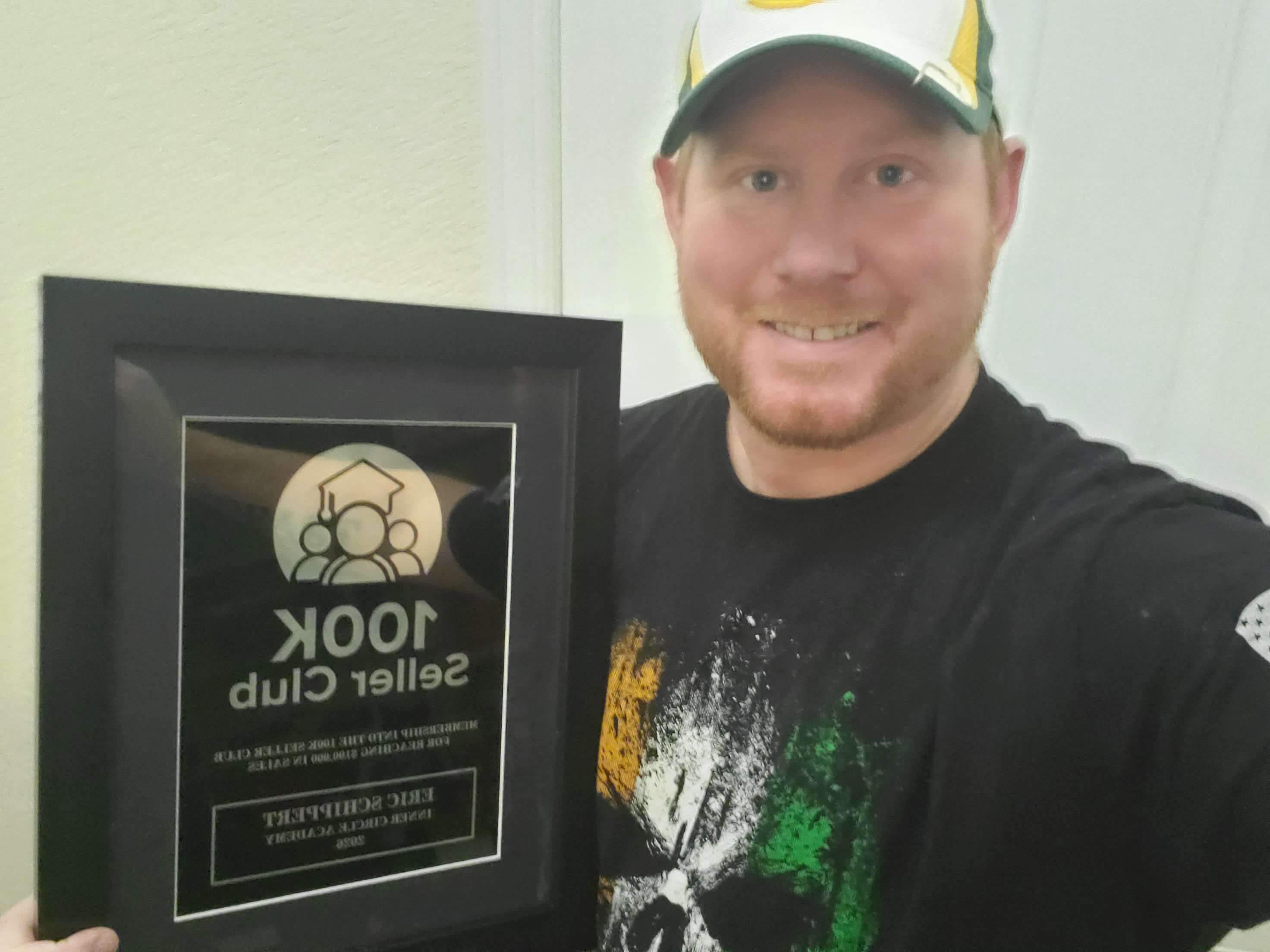 Eric Schippert holding his Inner Circle Academy 100K Seller Club plaque