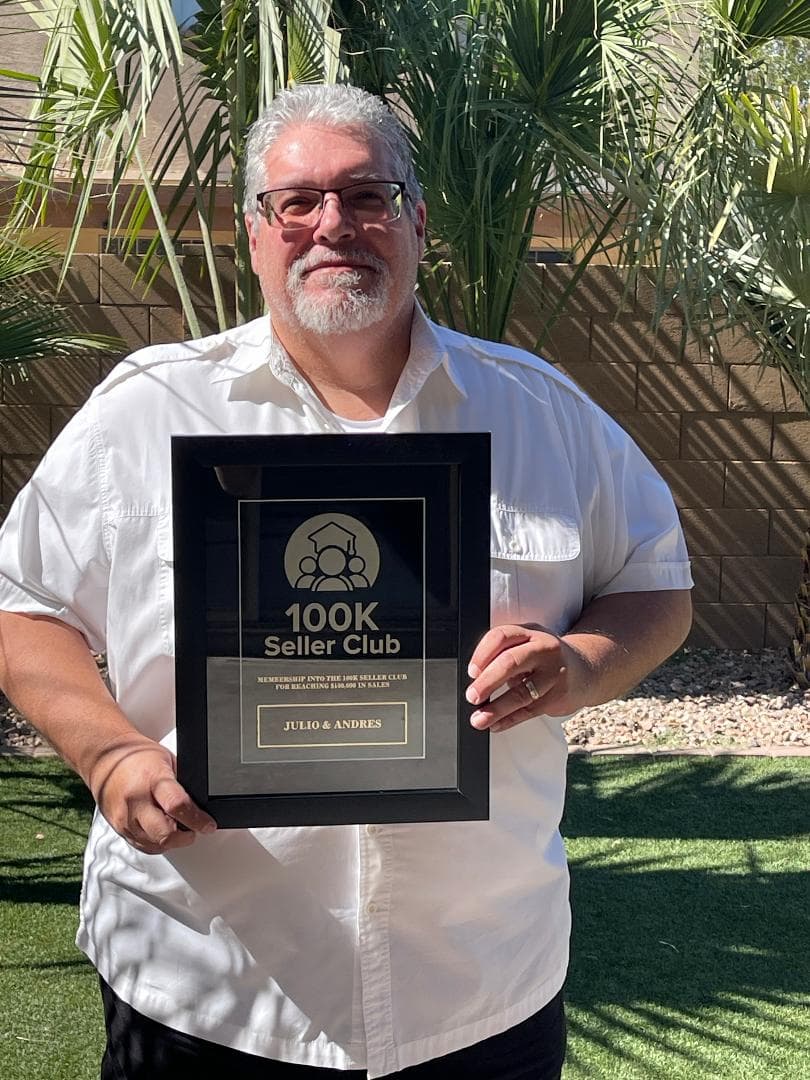 Julio Aguilar holding his Inner Circle Academy 100K Seller Club plaque
